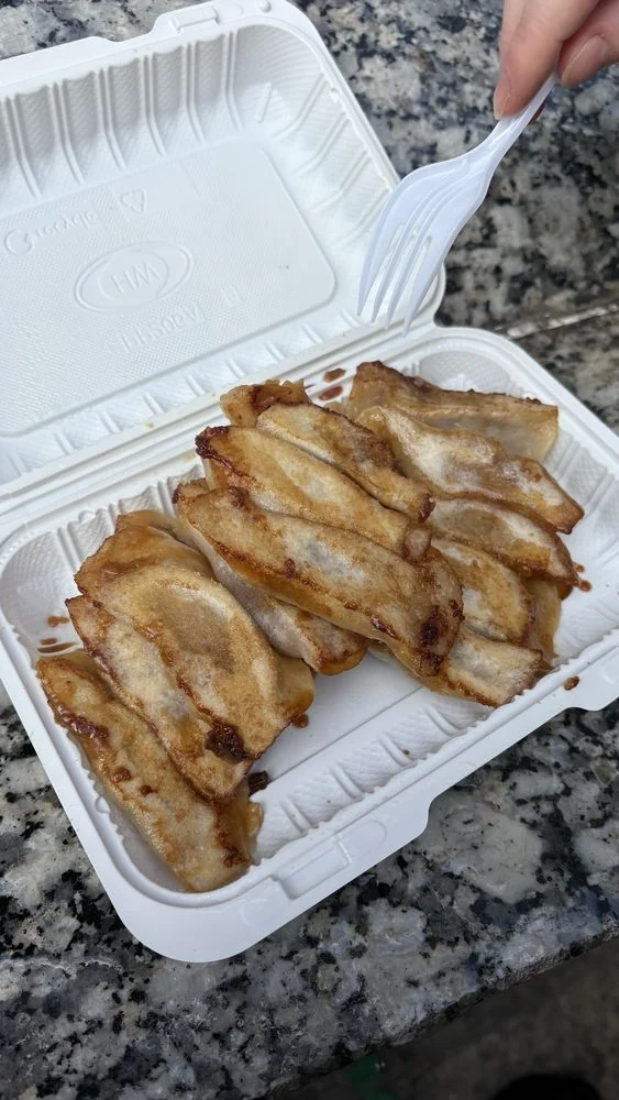 Pork and chive dumplings in a takeout box